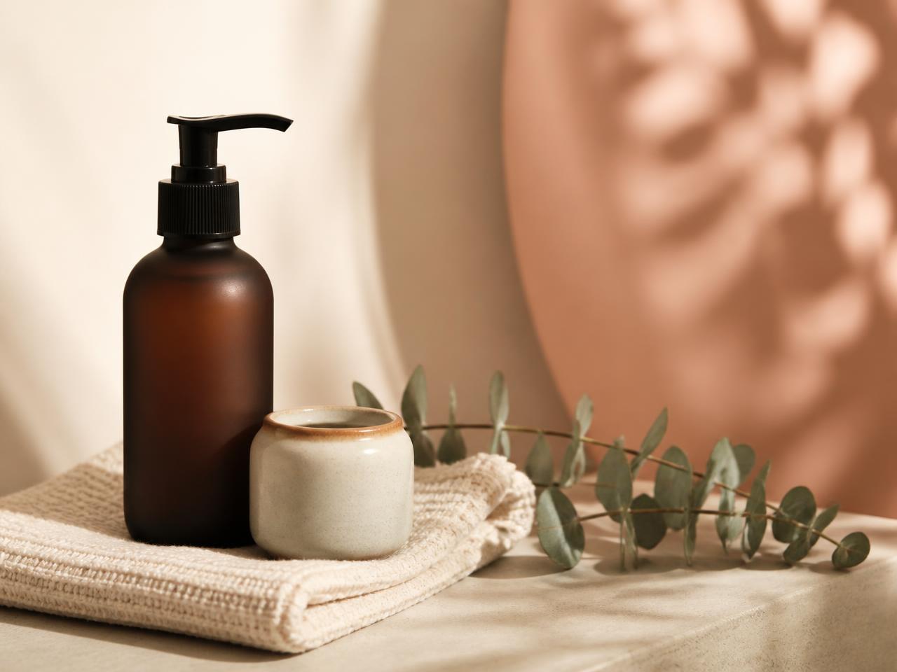 Haircare bottle and jar styled on a folded cream towel